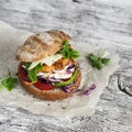 Homemade crispy fish burger on a light wooden board