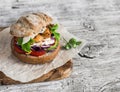 Homemade crispy fish burger on a rustic wooden board