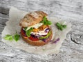 Homemade crispy fish burger on a rustic wooden board