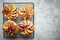 Homemade crumble tarts with fresh plum slices placed on iron baking grill