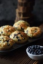 Homemade crumble top blueberry muffins with raw berries on black background. Low key still life with natural lighting Royalty Free Stock Photo