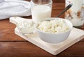 Homemade crumbly cottage cheese on a wooden background.