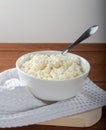 Homemade crumbly cottage cheese on a wooden background.