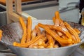 Homemade crunchy churros in steel bowl at summer outdoor food market