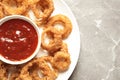 Homemade crunchy fried onion rings with sauce on color table, top view Royalty Free Stock Photo