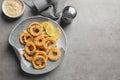 Homemade crunchy fried onion rings and sauce on gray background, top view Royalty Free Stock Photo