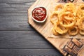 Homemade crunchy fried onion rings and sauce on wooden background, top view Royalty Free Stock Photo