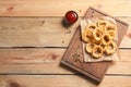 Homemade crunchy fried onion rings and tomato sauce on wooden background, top view Royalty Free Stock Photo