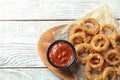 Homemade crunchy fried onion rings with tomato sauce on wooden table Royalty Free Stock Photo