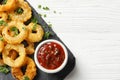 Homemade crunchy fried onion rings with tomato sauce on wooden table, top view Royalty Free Stock Photo