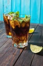 Homemade Cuba Libre with fresh lime, brown rum and crushed ice on an old wooden table Royalty Free Stock Photo