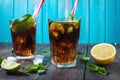 Homemade Cuba Libre with fresh lime, brown rum and crushed ice on an old wooden table Royalty Free Stock Photo