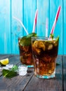 Homemade Cuba Libre with fresh lime, brown rum and crushed ice on an old wooden table Royalty Free Stock Photo