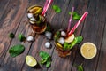 Homemade Cuba Libre with fresh lime, brown rum and crushed ice on an old wooden table Royalty Free Stock Photo