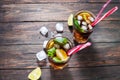 Homemade Cuba Libre with fresh lime, brown rum and crushed ice on an old wooden table Royalty Free Stock Photo