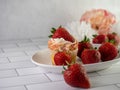 Homemade cupcake with sprinkles and fresh strawberries on a white plate Royalty Free Stock Photo