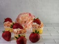 Homemade cupcakes with sprinkles and fresh strawberries on the floor Royalty Free Stock Photo