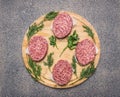 Homemade cutlet of beef for burgers, lined circle on a round wooden chopping board parsley and dill and spices