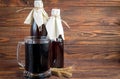 Homemade dark beer in bottles and a glass on a dark background. Nearby are barley grains and ears of wheat. Dark background Royalty Free Stock Photo