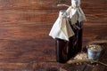 Homemade dark beer in bottles and a glass on a dark background. Nearby are barley grains and ears of wheat. Dark background Royalty Free Stock Photo