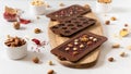 Homemade dark chocolate bars and pralines in molds with dried berries and nuts on white background. Side view. Chocolatier work Royalty Free Stock Photo