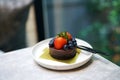 Homemade dark chocolate cake with cookies crust pie, topped with fresh strawberry, blueberry on marble table. Royalty Free Stock Photo