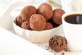 Homemade dark chocolate vegan truffles with nuts plate light background. Selective focus