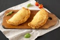 Homemade Deep Fried Italian Panzerotti Calzone on a rustic wooden board on a black background, low angle view. Close-up Royalty Free Stock Photo