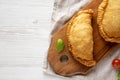 Homemade Deep Fried Italian Panzerotti Calzone on a rustic wooden board on a white wooden background, top view. Flat lay, overhead Royalty Free Stock Photo
