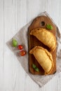 Homemade Deep Fried Italian Panzerotti Calzone on a rustic wooden board on a white wooden background, top view. Flat lay, overhead Royalty Free Stock Photo