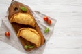 Homemade Deep Fried Italian Panzerotti Calzone on a rustic wooden board on a white wooden table, top view. Flat lay, overhead, Royalty Free Stock Photo