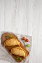 Homemade Deep Fried Italian Panzerotti Calzone on a rustic wooden board on a white wooden table, top view. Flat lay, overhead, Royalty Free Stock Photo