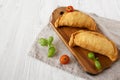 Homemade Deep Fried Italian Panzerotti Calzone on a rustic wooden board on a white wooden background, low angle view. Copy space Royalty Free Stock Photo