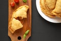 Homemade Deep Fried Italian Panzerotti Calzone with sauce on a black surface, top view. Flat lay, overhead, from above Royalty Free Stock Photo