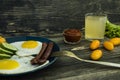 Homemade delicious breakfast with sunny side up fried egg, sausage, tomatos in top view Royalty Free Stock Photo