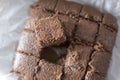Homemade delicious brownie on a white baking paper, close up