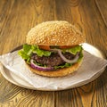 Homemade delicious hamburger on a wooden table, rustic style. Fast food. Space for the text