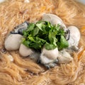 Delicious oyster vermicelli in a bowl on wooden table background