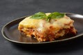 Homemade delicious Meat lasagna with basil leaf on the top.  Italian Lasagna with bachamel sauce on gray background. Royalty Free Stock Photo