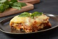 Homemade delicious Meat lasagna with basil leaf on the top.  Italian Lasagna with bachamel sauce on gray background. Royalty Free Stock Photo