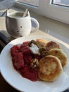Homemade delicious morning breakfast with a cup of tea, cottage cheese pancakes, strawberry jam and nuts Royalty Free Stock Photo