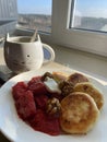 Homemade delicious morning breakfast with a cup of tea, cottage cheese pancakes, strawberry jam and nuts Royalty Free Stock Photo