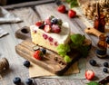 Homemade delicious slice of raspberry biscuit cake with white cream, strawberries, blueberries Royalty Free Stock Photo