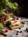 Homemade delicious slice of raspberry biscuit cake with white cream, strawberries, blueberries Royalty Free Stock Photo