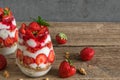 Homemade delicious strawberry yogurt parfait with granola, mint and fresh berries in glasses on rustic wooden tabl Royalty Free Stock Photo