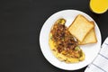 Homemade Denver Omelette on a white plate on a black background, top view. Flat lay, overhead, from above. Copy space