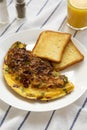 Homemade Denver Omelette on a white plate on cloth, low angle view