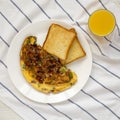 Homemade Denver Omelette on a white plate on cloth, overhead view. Flat lay, top view, from above