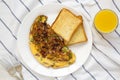 Homemade Denver Omelette on a white plate on cloth, top view. Flat lay, overhead, from above