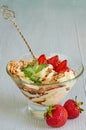 Homemade dessert with sliced strawberries, whipped cream and chocolate splash in the glass bowls on the gray kitchen background Royalty Free Stock Photo